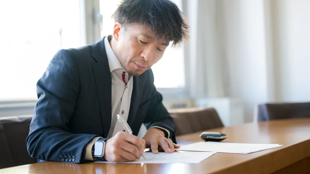 長文の開示資料を確認し赤入れする担当者